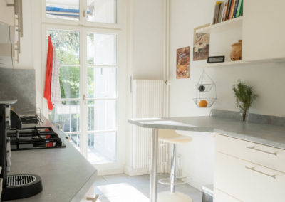 Wohnungsfoto - Küche Blick Richtung Balkon. Man sieht die Küchenzeile mit diversen Küchenutensilien und den Balkon